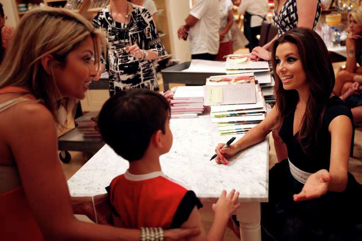 Eva Longoria, right, greets customers at a signing event for her first cookbook, "Eva's Kitchen: Cooking with Love for Family and Friends", June 4, 2011, at Williams-Sonoma at the Shops at La Cantera. Only people with on of 400 tickets were allowed to get Longoria's signature in their books. ANDREW BUCKLEY / abuckley@express-news.net
