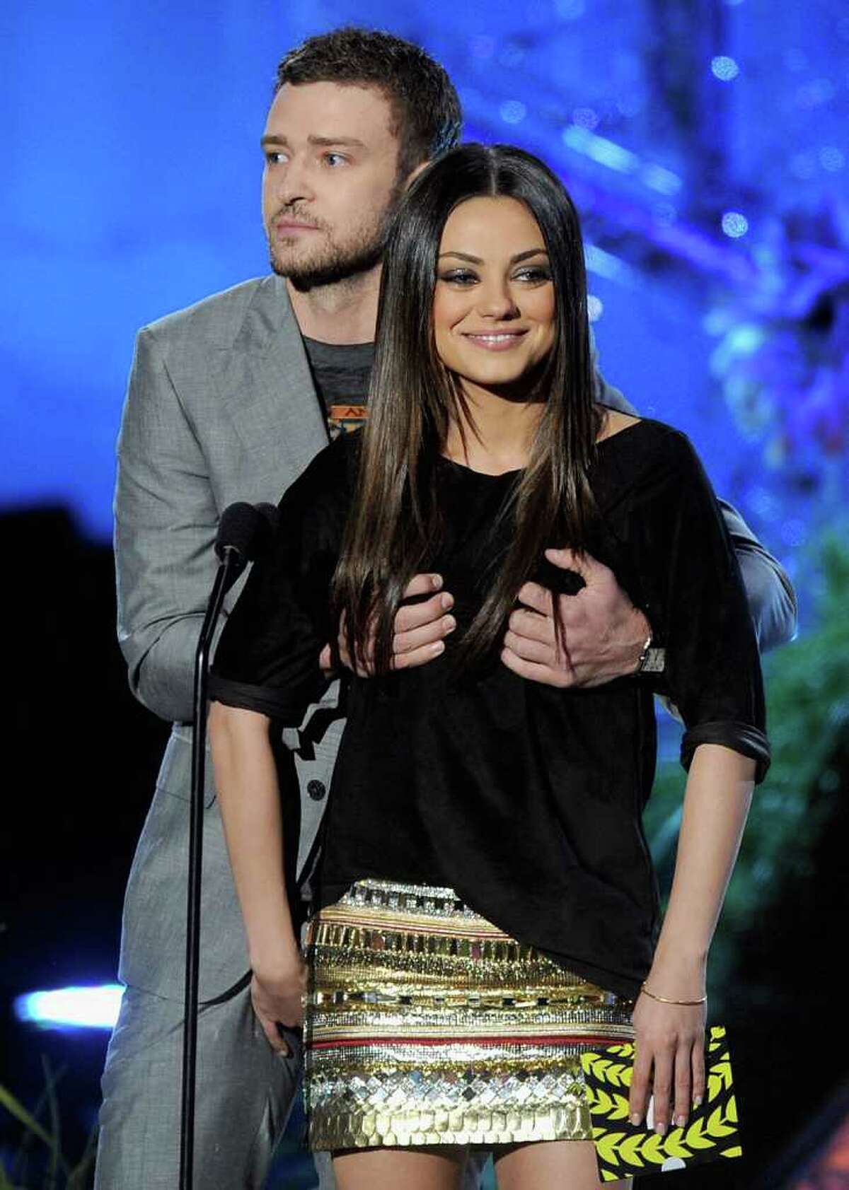 Actors Justin Timberlake (L) and Mila Kunis present an award onstage.