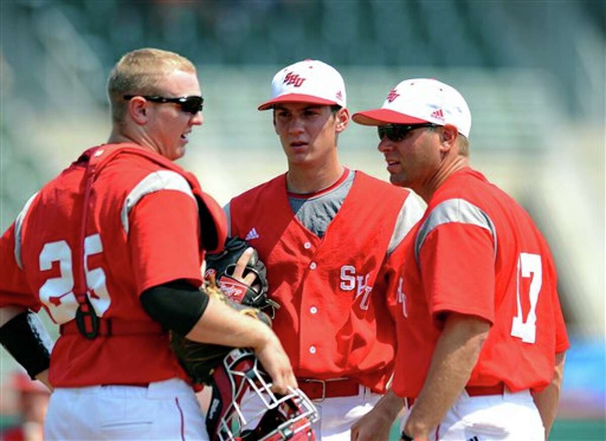 Sacred Heart's pitching coach Wayne Mazzoni, right, talks with pitcher Nick Leiningen, center, and catcher Derick Horn (25) at the mound during an NCAA Clemson regional college baseball game against Connecticut at Doug Kingsmore Stadium in Clemson, S.C. Saturday, June 4, 2011. (AP Photo/ Richard Shiro)