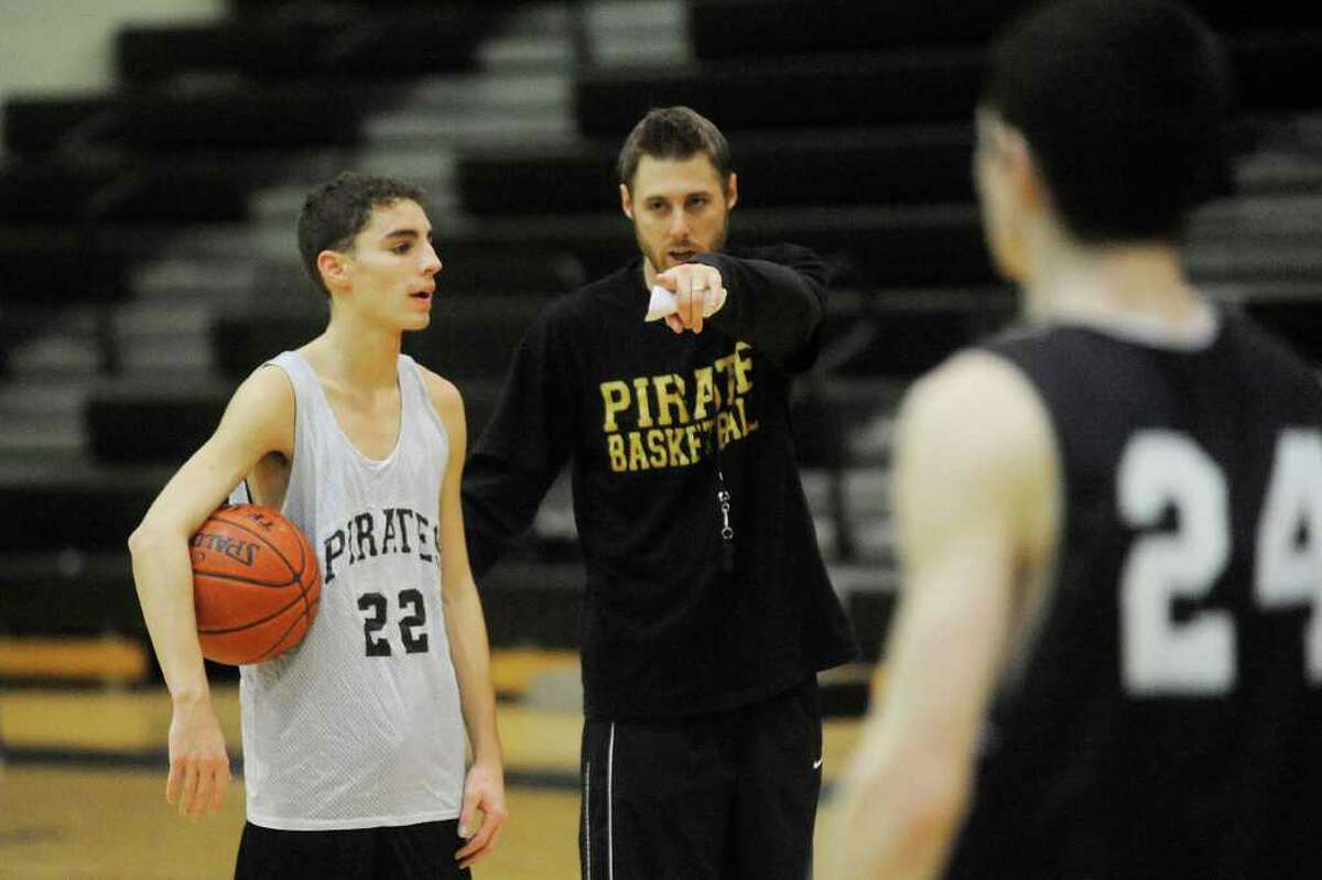 Vidor boys basketball coach Zach Quinn, center, works with Jacob Rhodes, left, and the Pirates basketball team to get ready for the opening District 20-4A season on Friday. Thursday. December 17, 2009. Valentino Mauricio/The Enterprise