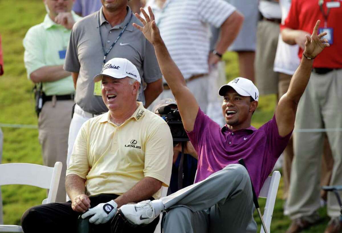 Tiger Woods and Mark O'Meara, left, cheer after Wood's caddie Steve Williams, not shown, makes a shot on the 17th green during a practice round for The Players Championship golf tournament, Wednesday May 11, 2011 in Ponte Vedra Beach, Fla. (AP Photo/Chris O'Meara)
