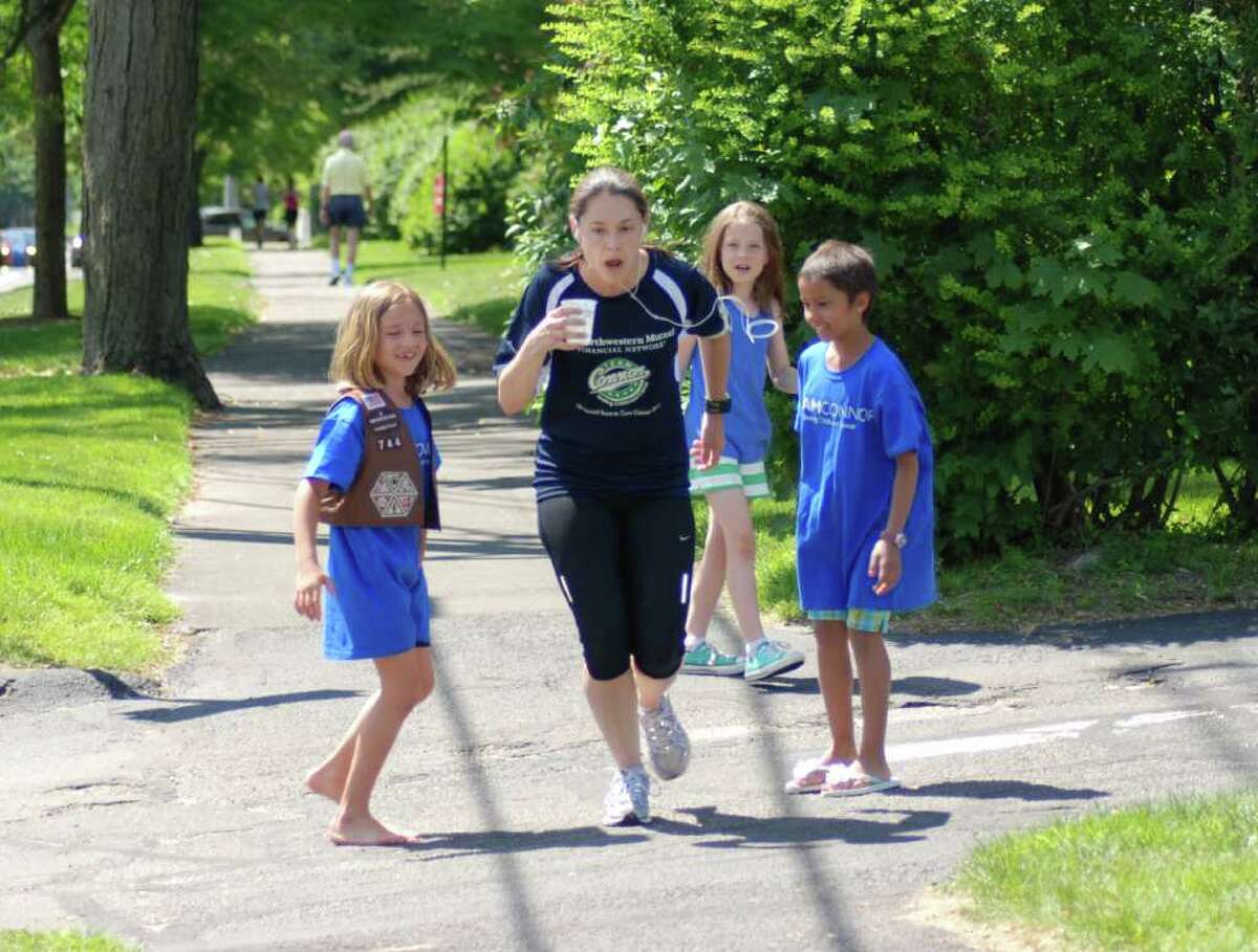 East School 2nd grade Brownie Troop 121 manned the water station at the Methodist Church on Saturday afternoon for Team Connor's One Mile At A Time Relay. Milly Murphy, Vivi Reeves, and Ashley Ruth excitedly handed over a cup of water to their troop leader Patty Zoccolillo.