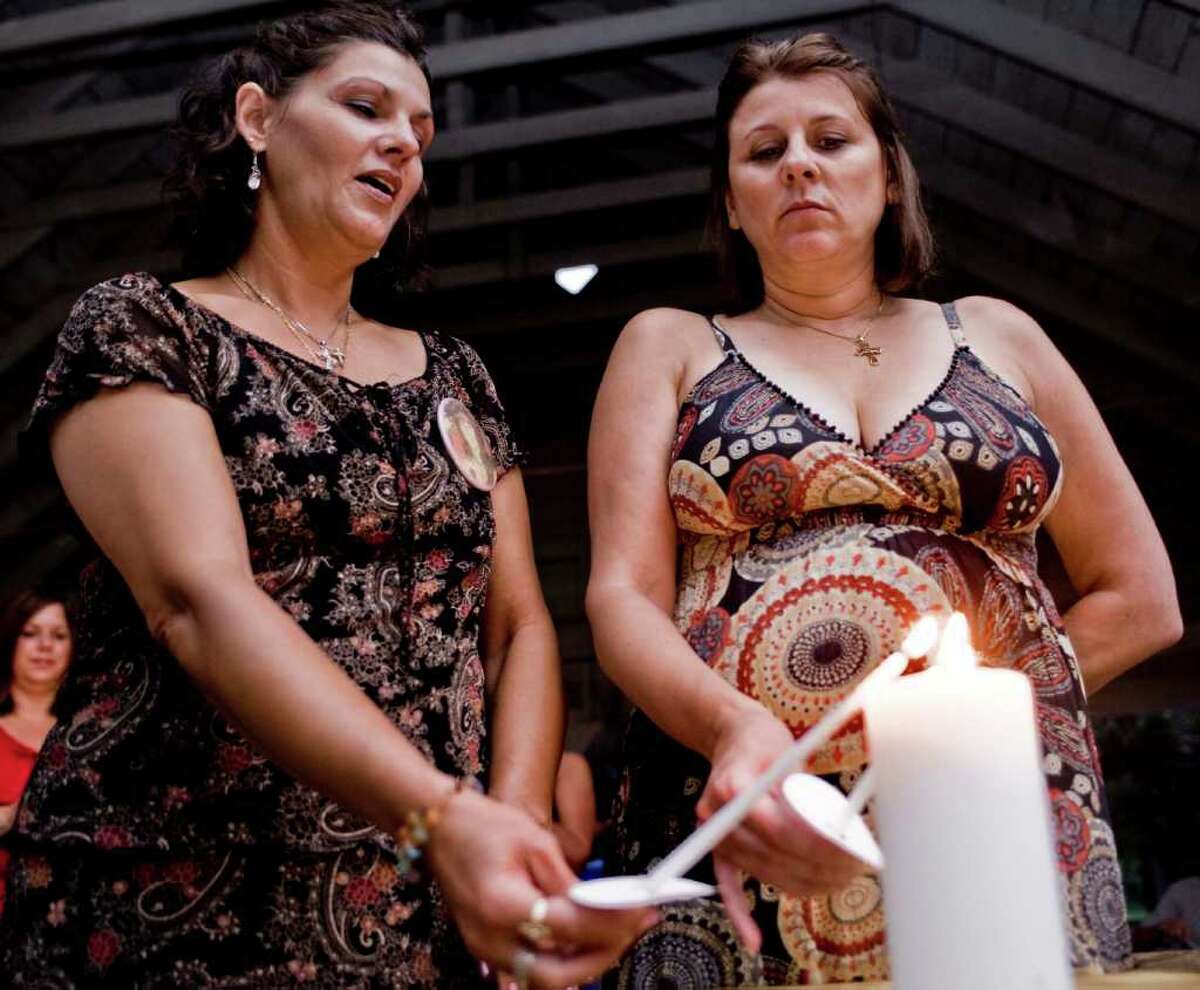 Sisters Beth Protefa of Torrington and Sherrie Passaro of Danbury light candles during a 2009 prayer vigil for their mother, Mary Badaracco. The vigil was held to observe the 25 years since Badaracco’s disappearance.