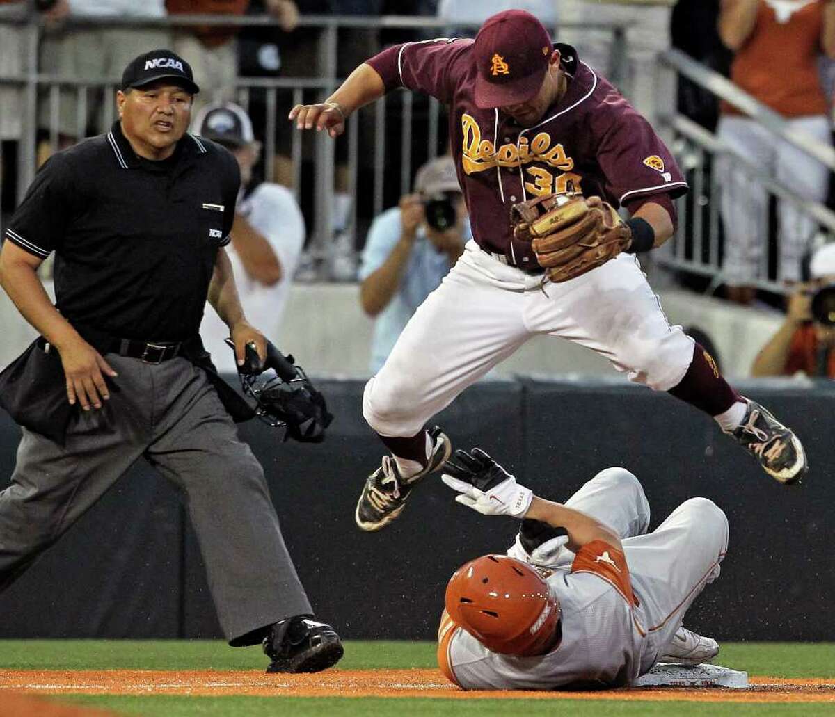 Arizona State third baseman Riccio Torrez leaps over the slide of Tant Sheperd who is safe for a triple in the last inning as the Texas Longhorns play Arizona State in game 2 of their super regional playoff series at Disch-Falk Field in Austin on June 11, 2011. Tom Reel/Staff