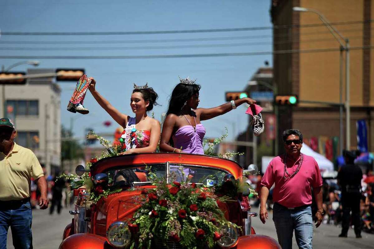 metro - Miss San Antonio Domonique Ramirez, left, and Miss Bexar County Ashley Dixon, right, show their shoes during the Battle of Flowers Parade in San Antonio on Friday, April 15, 2011. LISA KRANTZ/lkrantz@express-news.net