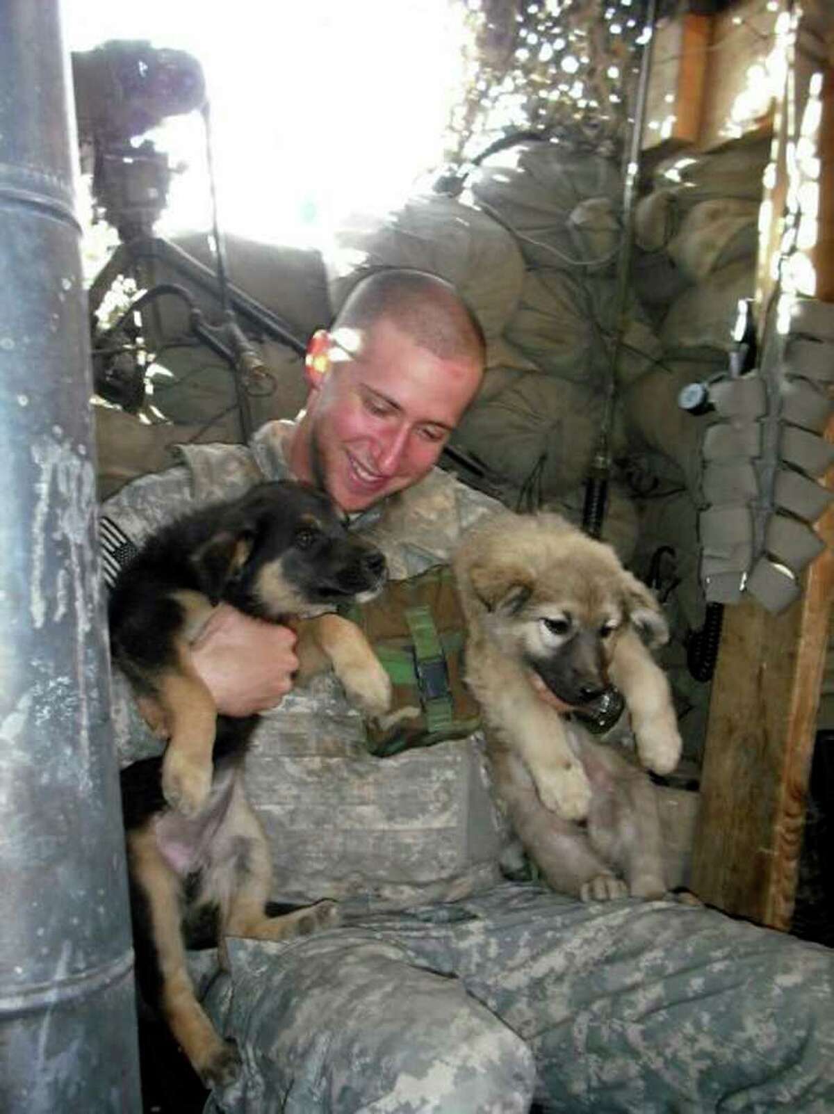 Sgt. Glenn Sewell with a pair of furry friends in Iraq. He already had served in Afghanistan.