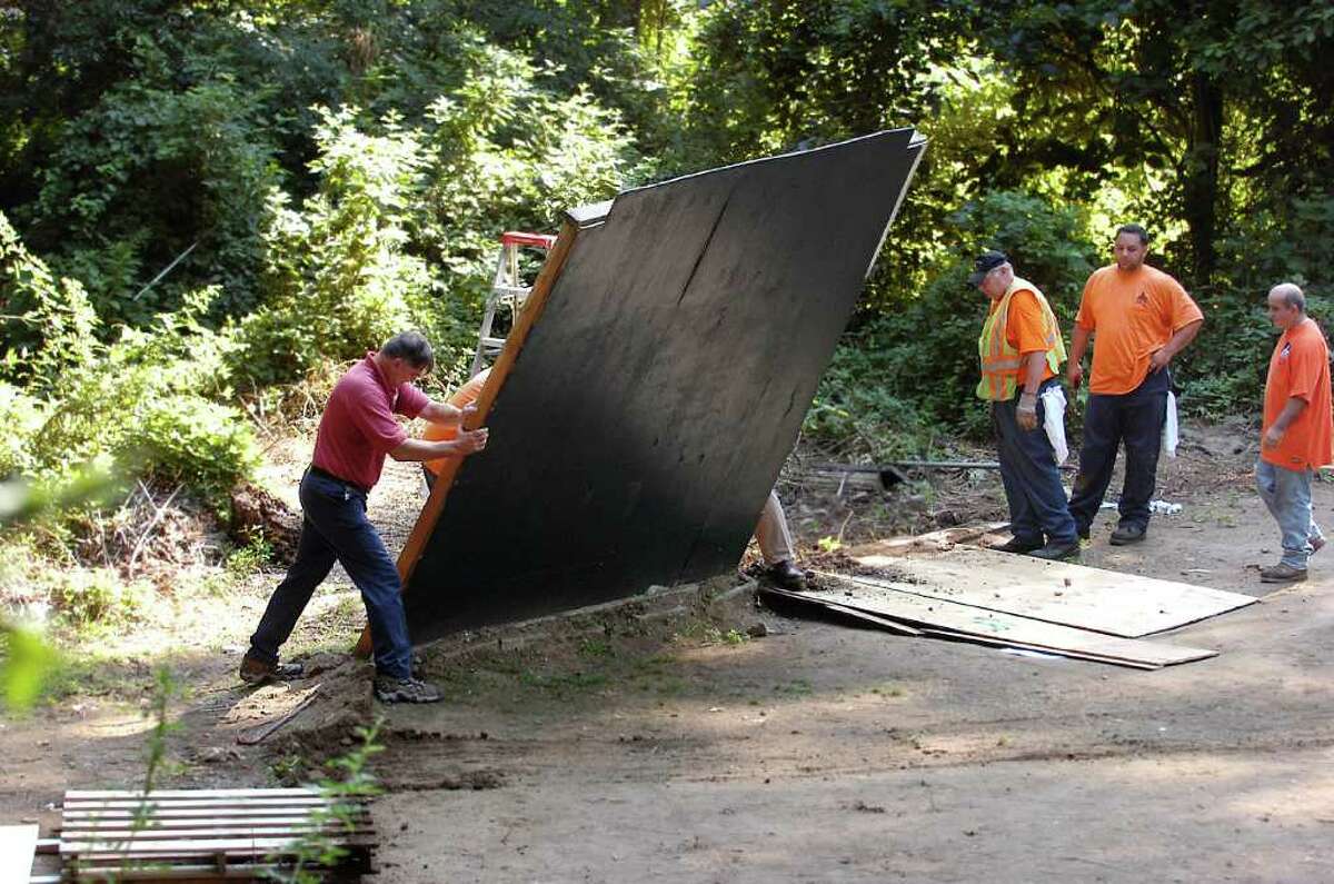 Town workers take down the "Green Monster" section of wall at the Riverside Wiffle Ball Field, in this July 18, 2008, file photo. The town has narrowed the list of permanent locations for a Wiffle ball field, and says it’s open to recreating a miniature replica of the famed 36-foot-high wall at Fenway Park in Boston.