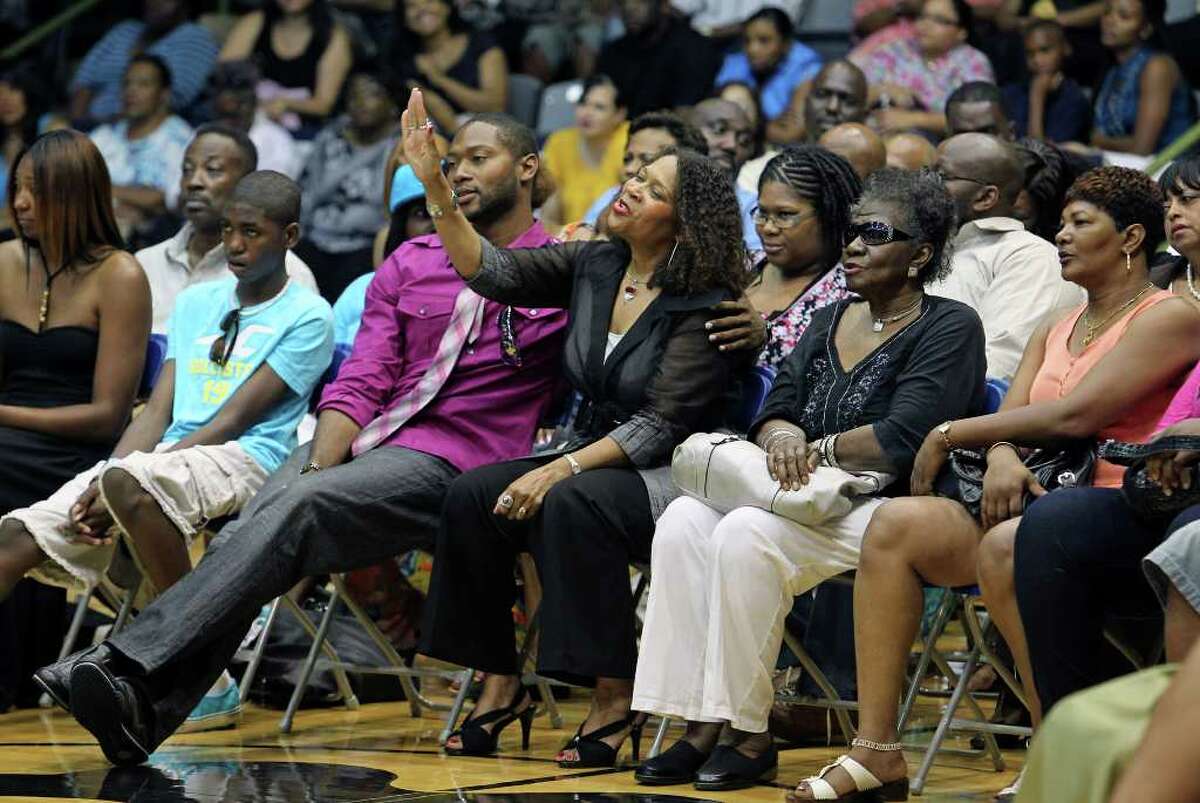 Diana Mitchell raises her hand as her son MIke Mitchell, Jr. comforts her during the memorial service for Spurs great Mike Mitchell at the Antioch Sports Center on June 16, 2011. The widow was responding to a chant called "Show Yourself Mighty" led by Earl Jackson, a minister at Antioch Church. Tom Reel/Staff