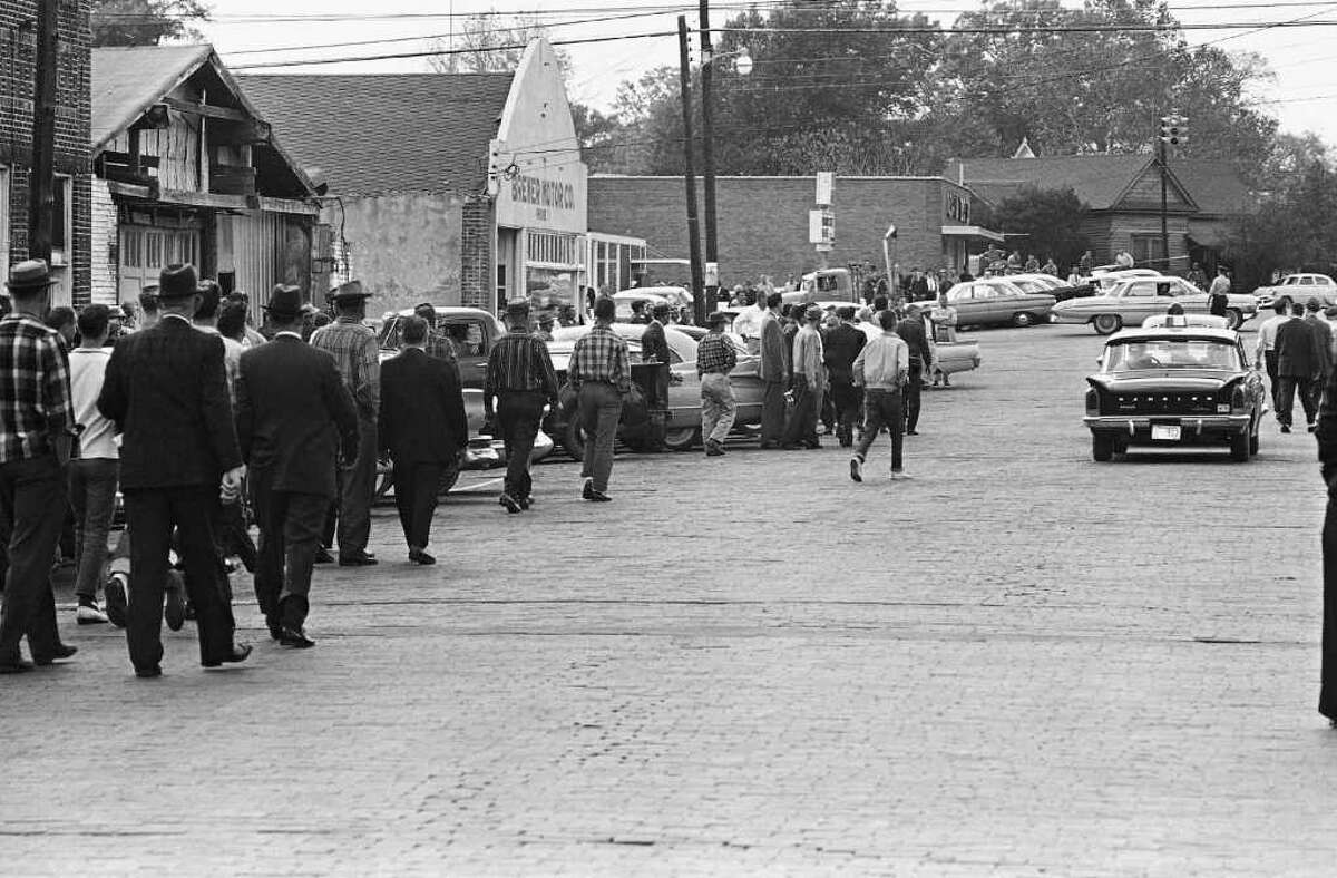 Police escort "Freedom Riders" from the bus station in McComb, Dec. 1, 1961, after they arrived on a bus with no incident. The crowd followed to the city hall where police took newsmen inside for protection. (AP Photo/Fred Kaufman)