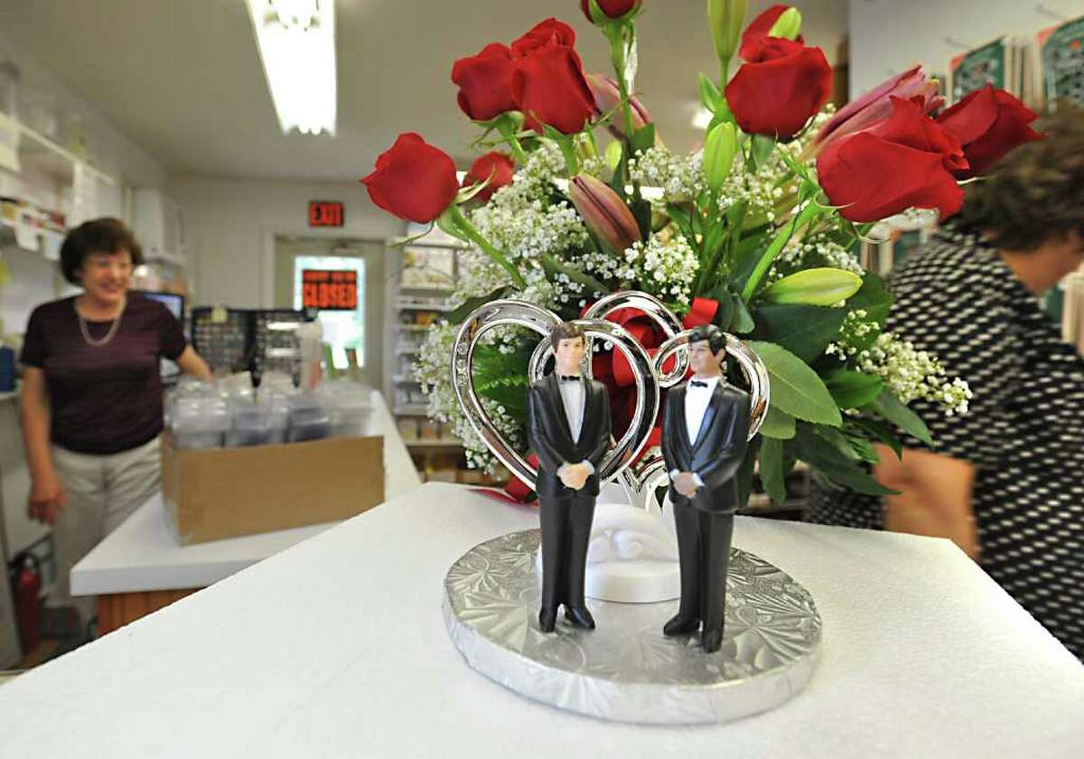 A same sex wedding cake topper is displayed on the counter at Confectionery House in Troy, N.Y. Friday June 17, 2011. Employee Chris Barbone, left, helps a customer. (Lori Van Buren / Times Union)
