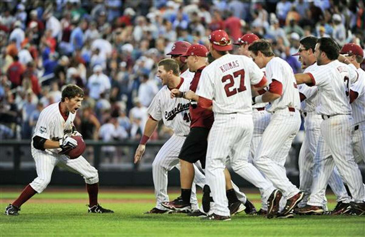 South Carolina's Scott Wingo, left, celebrates with teammates after knocking in the winning run against Texas A&M in the ninth inning of an NCAA College World Series baseball game in Omaha, Neb., Sunday, June 19, 2011. South Carolina beat Texas A&M 5-4. (AP Photo/Eric Francis)
