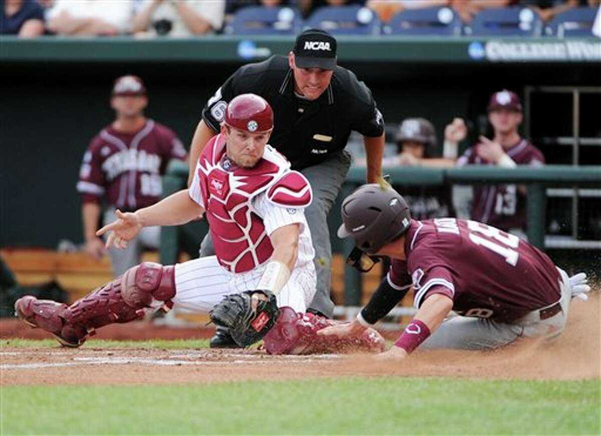 Texas A&M's Tyler Naquin, right, scores at home plate against South Carolina catcher Robert Beary, on a single by Jacob House in the first inning of an NCAA College World Series baseball game in Omaha, Neb., Sunday, June 19, 2011. (AP Photo/Eric Francis)
