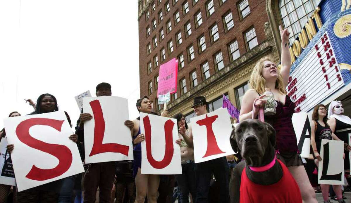 Ronni Avila and her Dog Izzy the "slut dog," pictured on the right, at the SlutWalk Seattle march.