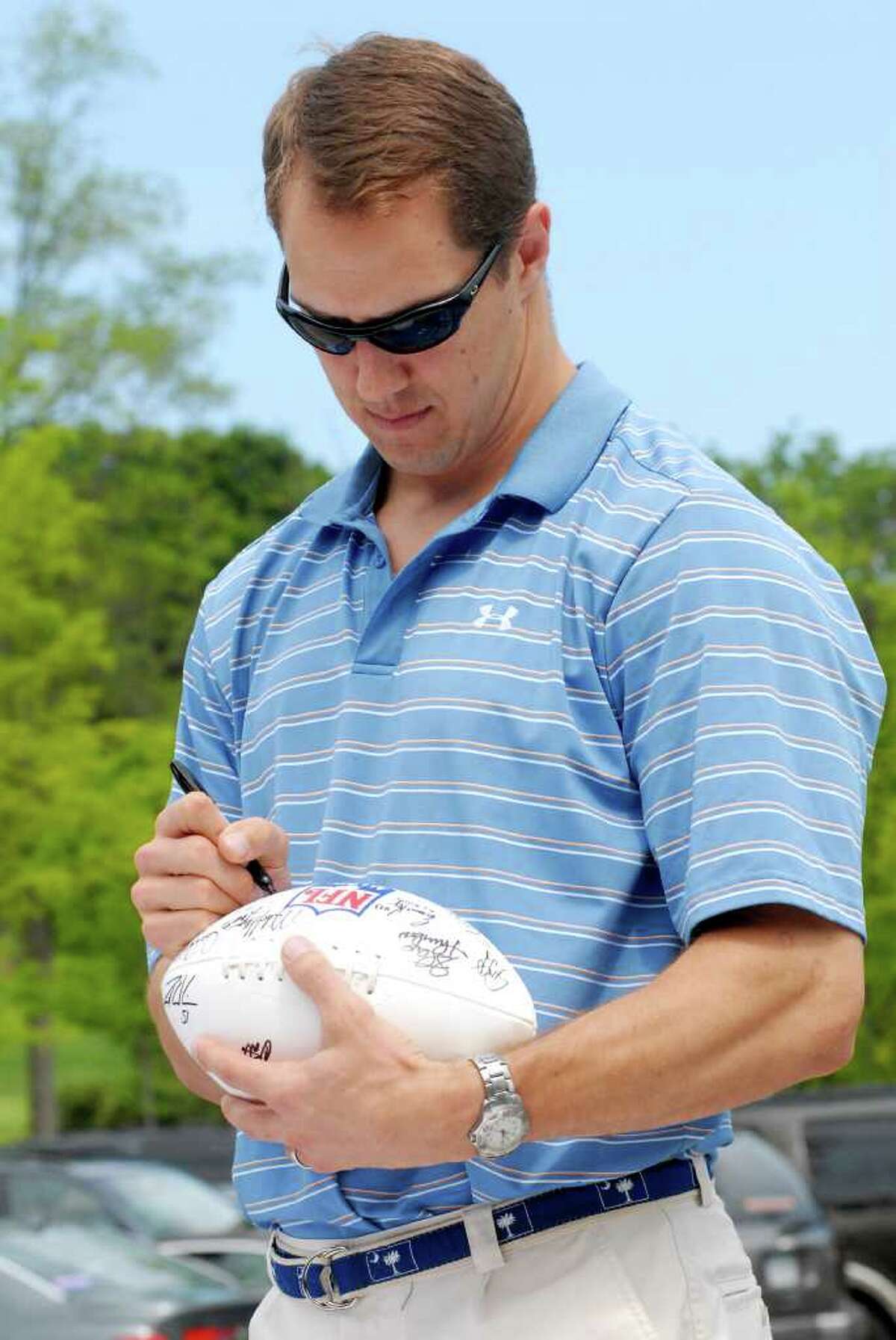 Patrick Kerney signs footballs at the NFL Alumni Connecticut Chapter 5th annual Celebrity Golf Classic at Country Club of Darien in Darien, Conn. on Monday June 20, 2011.
