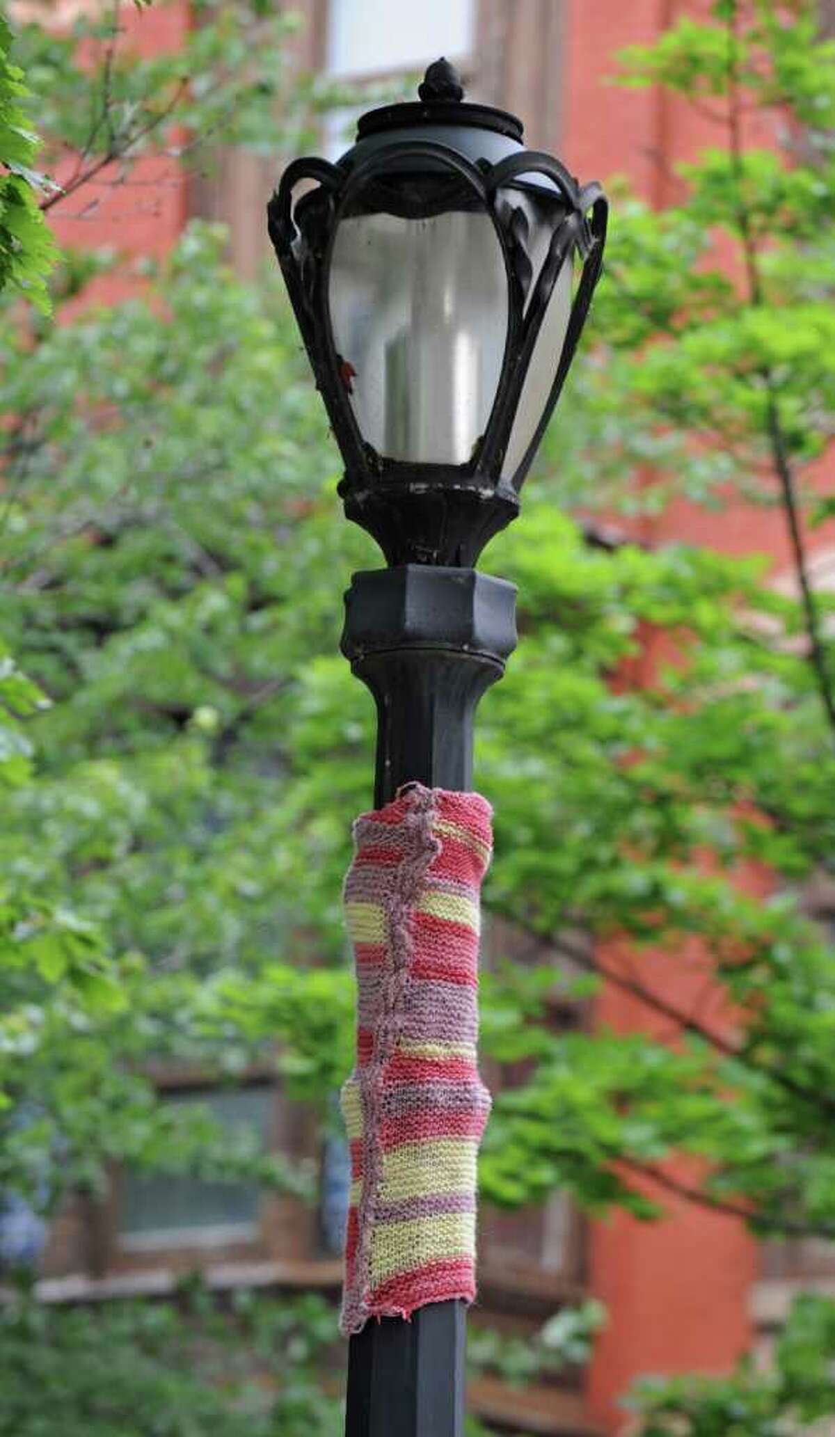 At the corner of 3rd Street and Washington Place, a "Yarn Bomber" has created a multi colored, knitted "cozy" covering part of the antique style light post in Troy, N.Y. Tuesday June 14, 2011. (Lori Van Buren / Times Union)