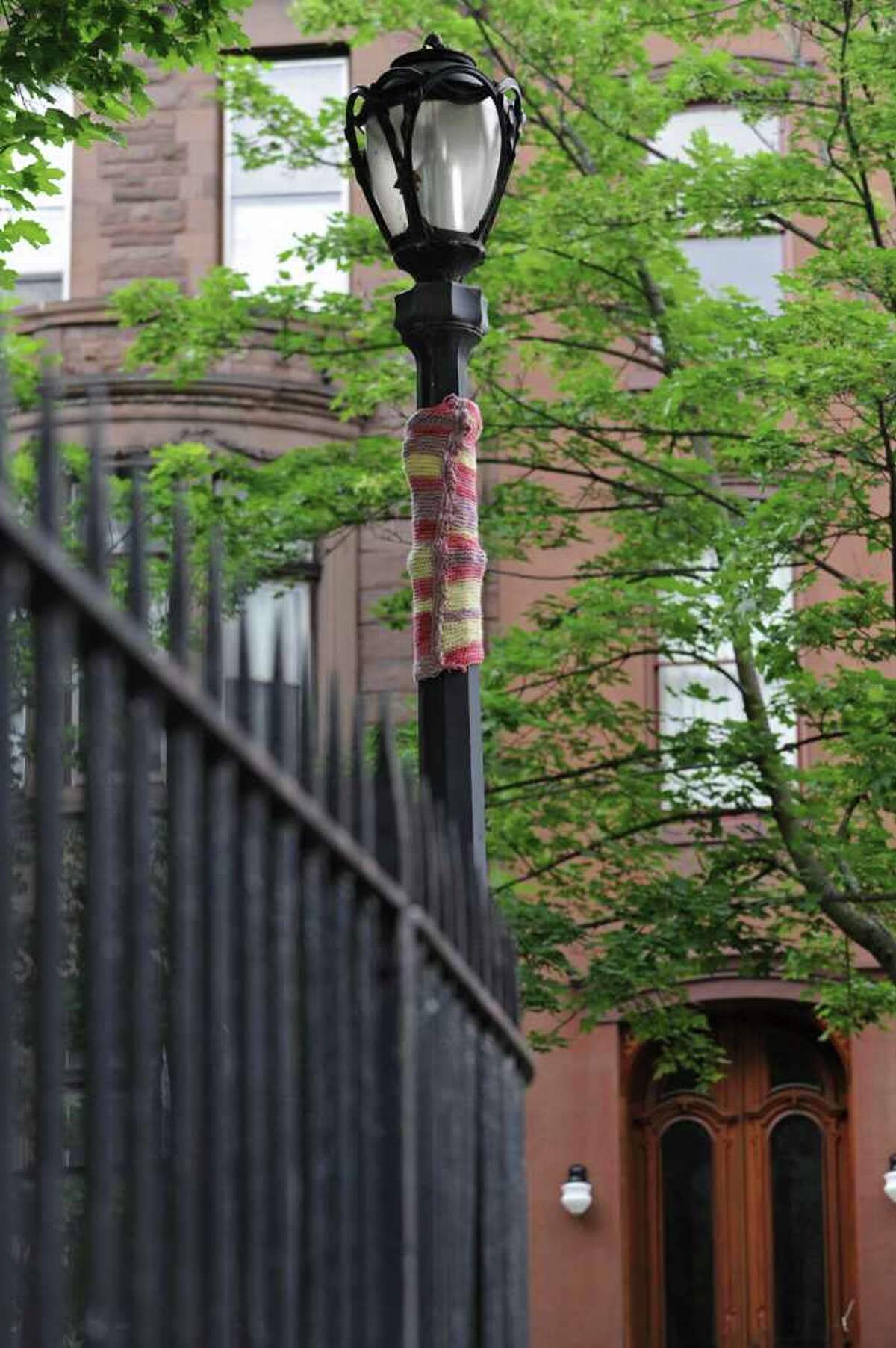 At the corner of 3rd Street and Washington Place, a "Yarn Bomber" has created a multi colored, knitted "cozy" covering part of the antique style light post in Troy, N.Y. Tuesday June 14, 2011. (Lori Van Buren / Times Union)