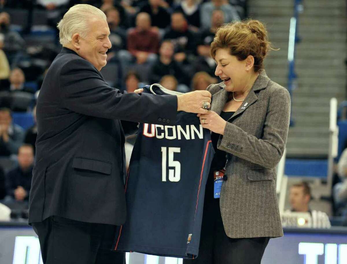 Larry McHugh, Chairman of the Board of Trustees at UConn, left, presents Susan Herbst, newly named 15th president of the University of Connecticut a Connecticut jersey during an NCAA basketball game in Hartford, Conn., Monday, Dec. 20, 2010. (AP Photo/Jessica Hill)