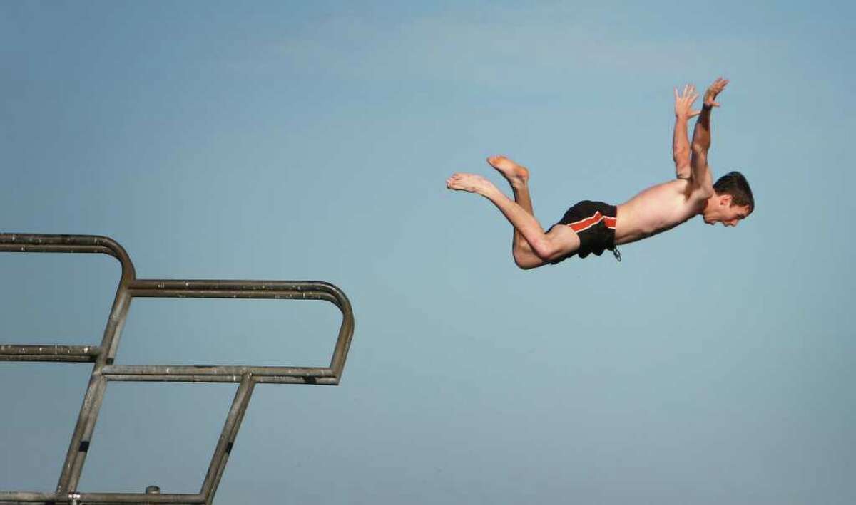 A diver leaps from a platform at Seattle's Green Lake Park on the first day of summer.