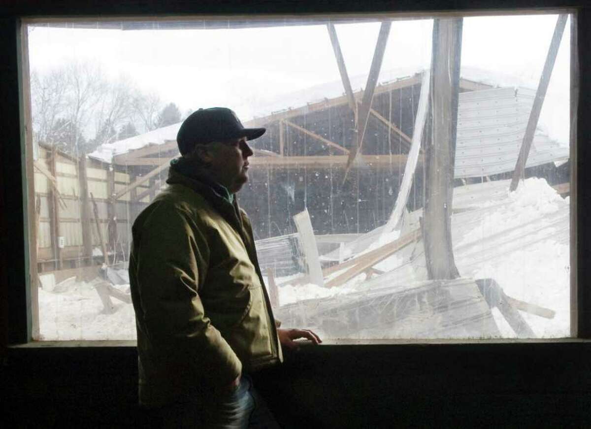Silvermine Farm owner Ken Markosky looks at the wreckage in his indoor riding arena on Thursday. The arena at his boarding stable in Norwalk collapsed under the pressure of snow on Thursday.