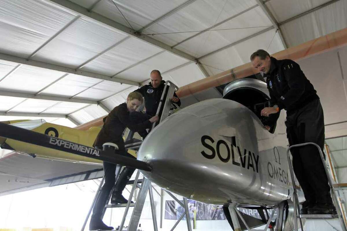 French Ecology Minister Nathalie Kosciusko-Morizet (L) climbs down a ladder next to Solar Impulse Swiss president and initiator Bertrand Piccard (2ndL) and Swiss project co-founder and CEO Andre Borschberg (R) as she discovers the solar-powered aircraft Solar Impulse at the Paris International Air Show on June 23, 2011 at Le Bourget airport, north of Paris. AFP PHOTO PIERRE VERDY