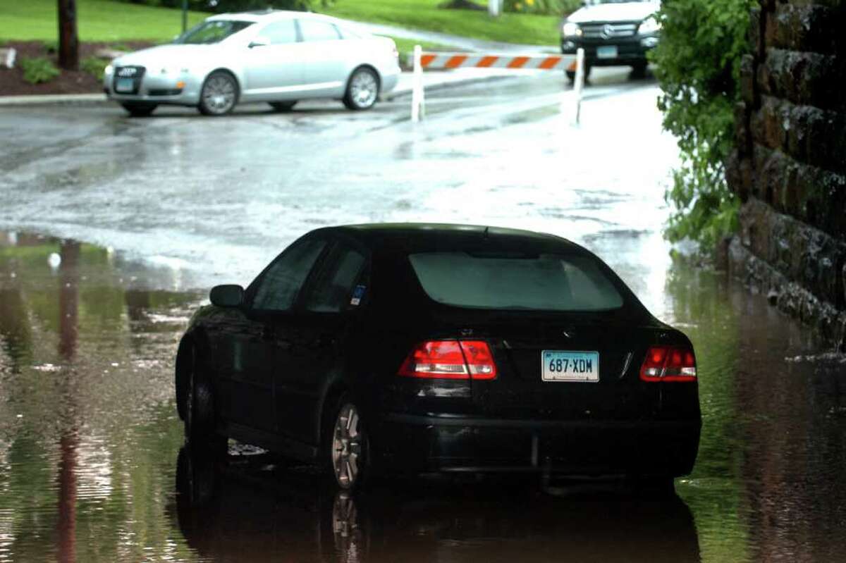 A car sits stranded in the flooded rail road underpass on Round Hill Rd. in Fairfield, Conn. Thursday, June 23rd, 2011.