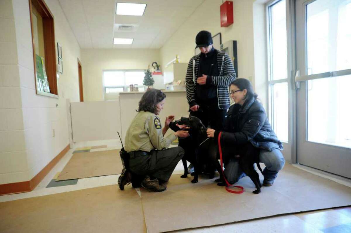 Animal Control Officer Suzanne Carlin, left, pets two brother dogs, in the new animal shelter in Greenwich on Wednesday, Jan. 5, 2011. Justin Smith and Catherine LoBalbo, of Cos Cob, adopted the dogs.