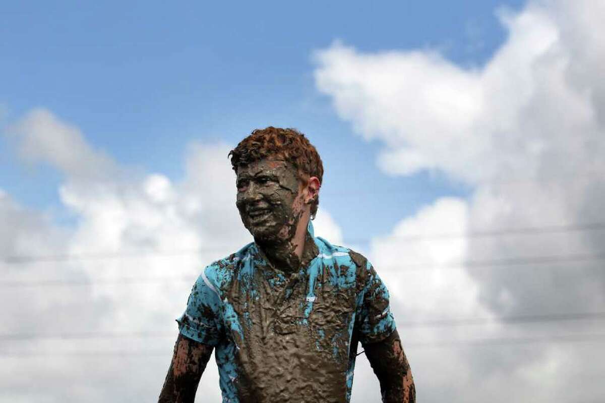Tom Wilder, 17 from Kent, laughs after he dived in the mud.