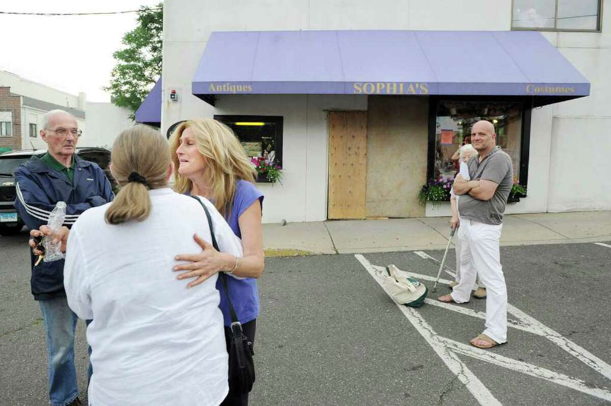Sophia Scarpelli, third from left, owner of Sophia's Costumes (background) at 1 Liberty Way in downtown Greenwich, reacts while being comforted by friends after a car drove through the front of her store late Saturday morning, June 25, 2011.