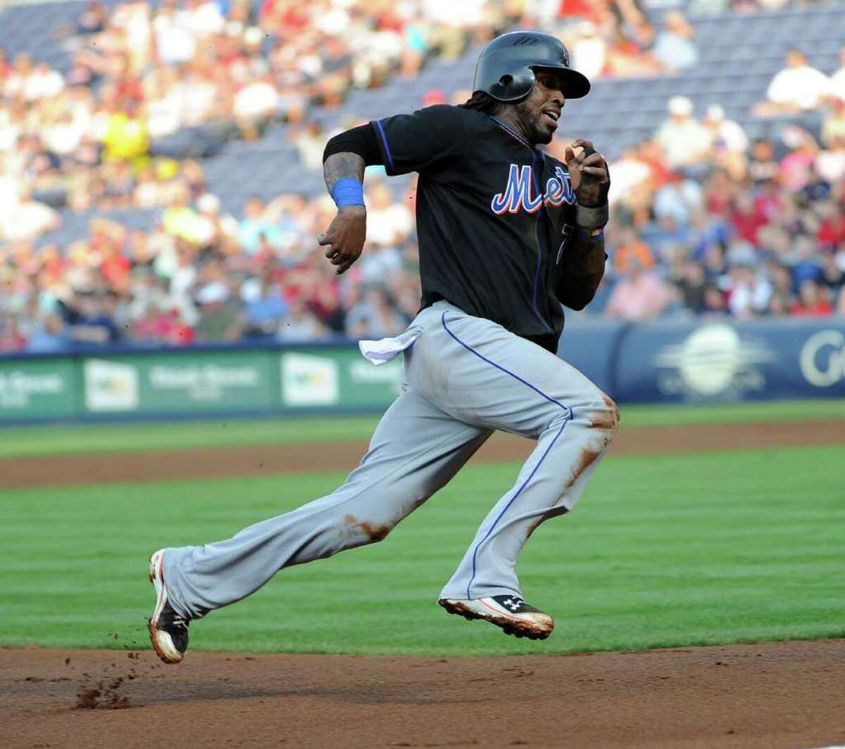 New York Mets' Jose Reyes rounds third base on his way to score on a single to centerfield by Carlos Beltran against the Atlanta Braves during the first inning of a baseball game, June 14, 2011, in Atlanta. (AP Photo/John Amis)