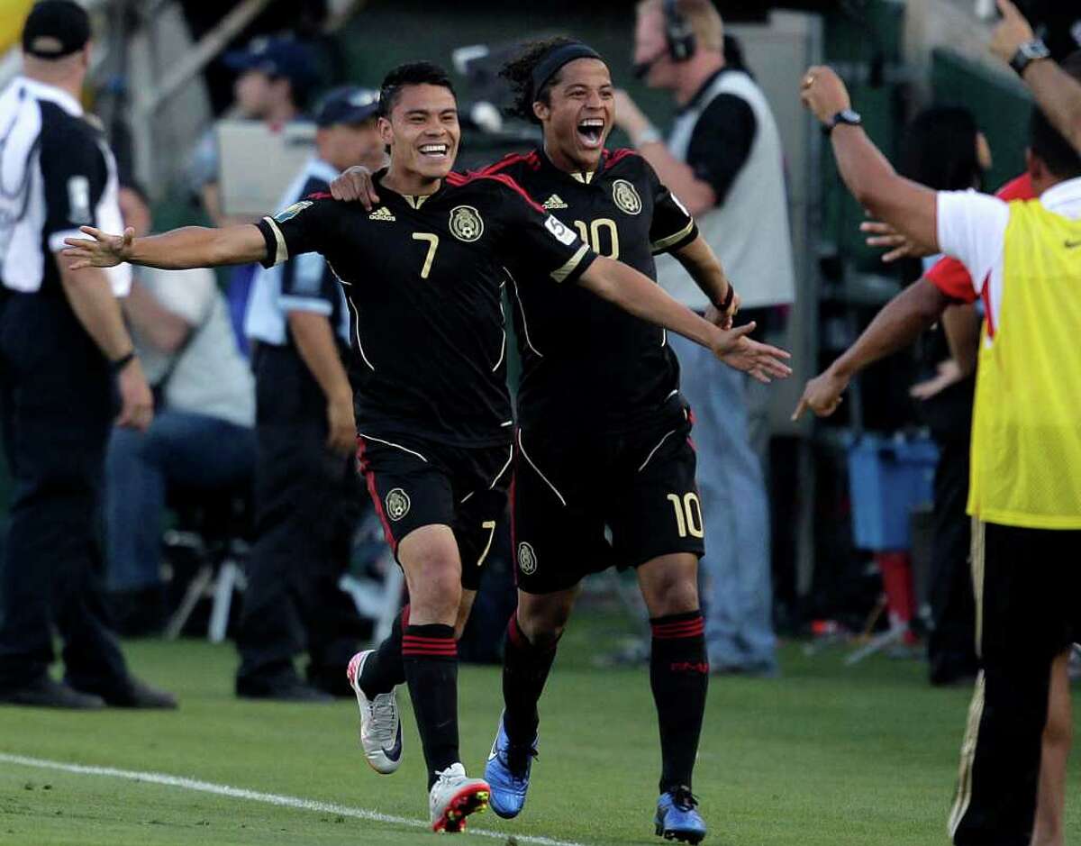 Mexico's Pablo Barrera, left, and Giovani Dos Santos celebrate after Barrera scored against United States during the second half of the CONCACAF Gold Cup soccer final game at the Rose Bowl in Pasadena, Calif., Saturday, June 25, 2011. (AP Photo/Jae C. Hong)