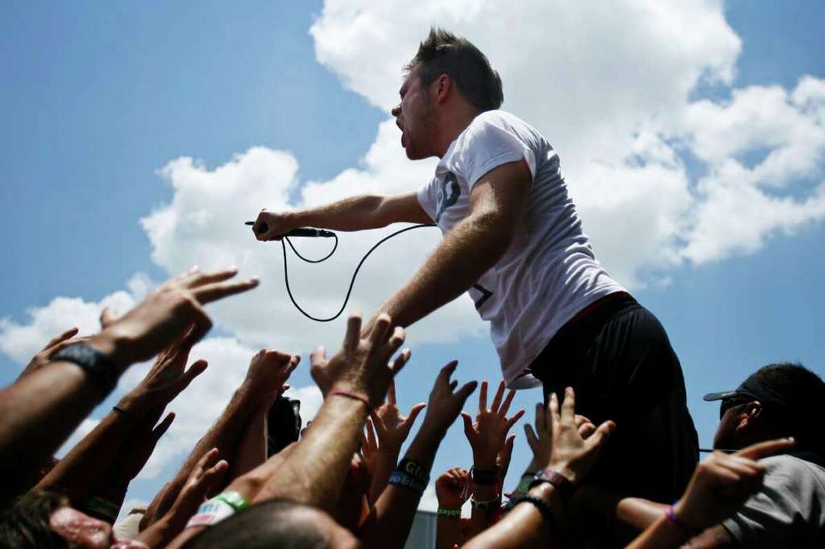 Roughton "Rou" Reynolds, lead vocalist of Enter Shikari climbs into the crowd during the Vans Warped Tour on Sunday, June 26, 2011 at the AT&T Center parking lot. Vans Warped Tour will vist over forty cities in the U.S. this summer. SALLY FINNERAN/sfinneran@express-news.net