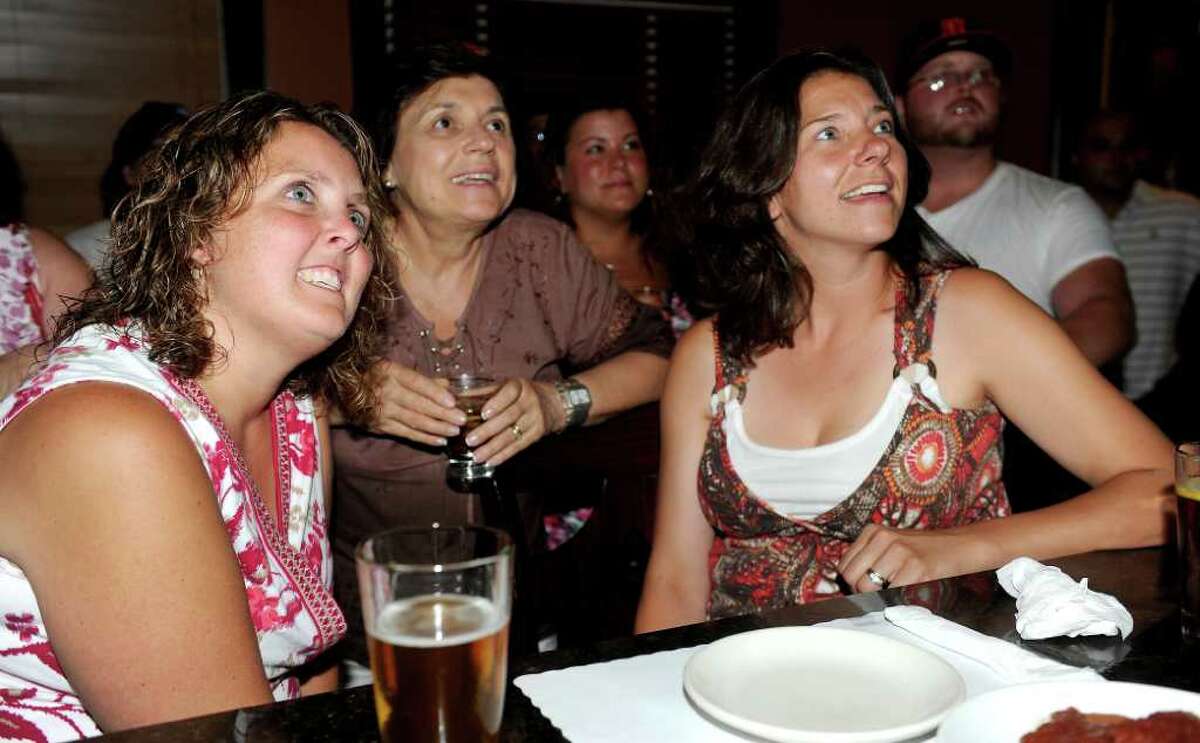 Michele Piccolo, left, Rosemary Hayduk, center, and Debra McGlone, right, watch Stratford-native Javier Colon compete in the finale of "The Voice" as fans watched at Paradise Pizza in Stratford on Tuesday, June 28, 2011.