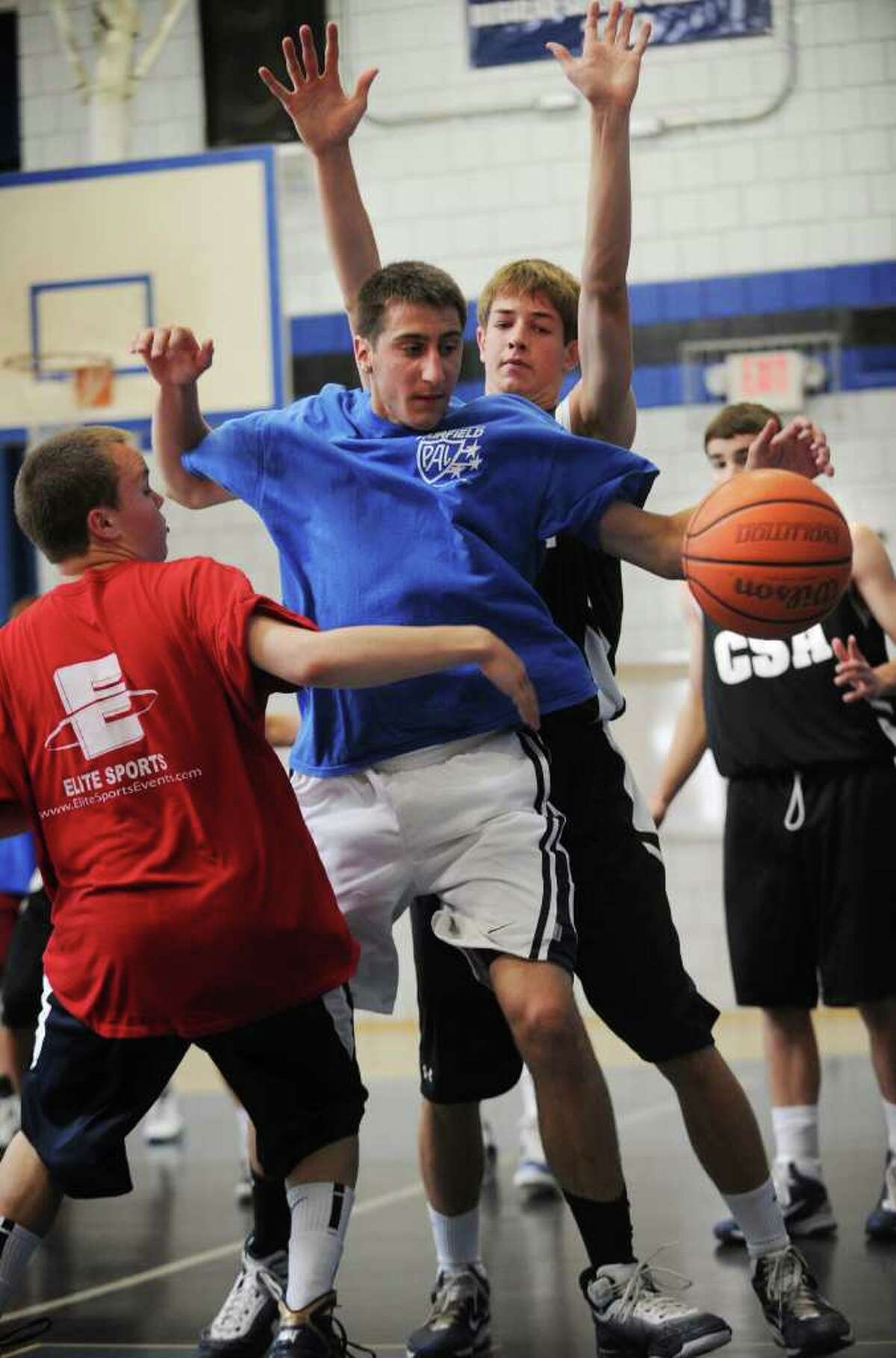 Fairfield Ludlowe's David Kinsley, center, goes after a rebound during a matchup against a team of all stars during summer basketball at Christian Heritage School in Trumbull on Sunday, June 16, 2011.