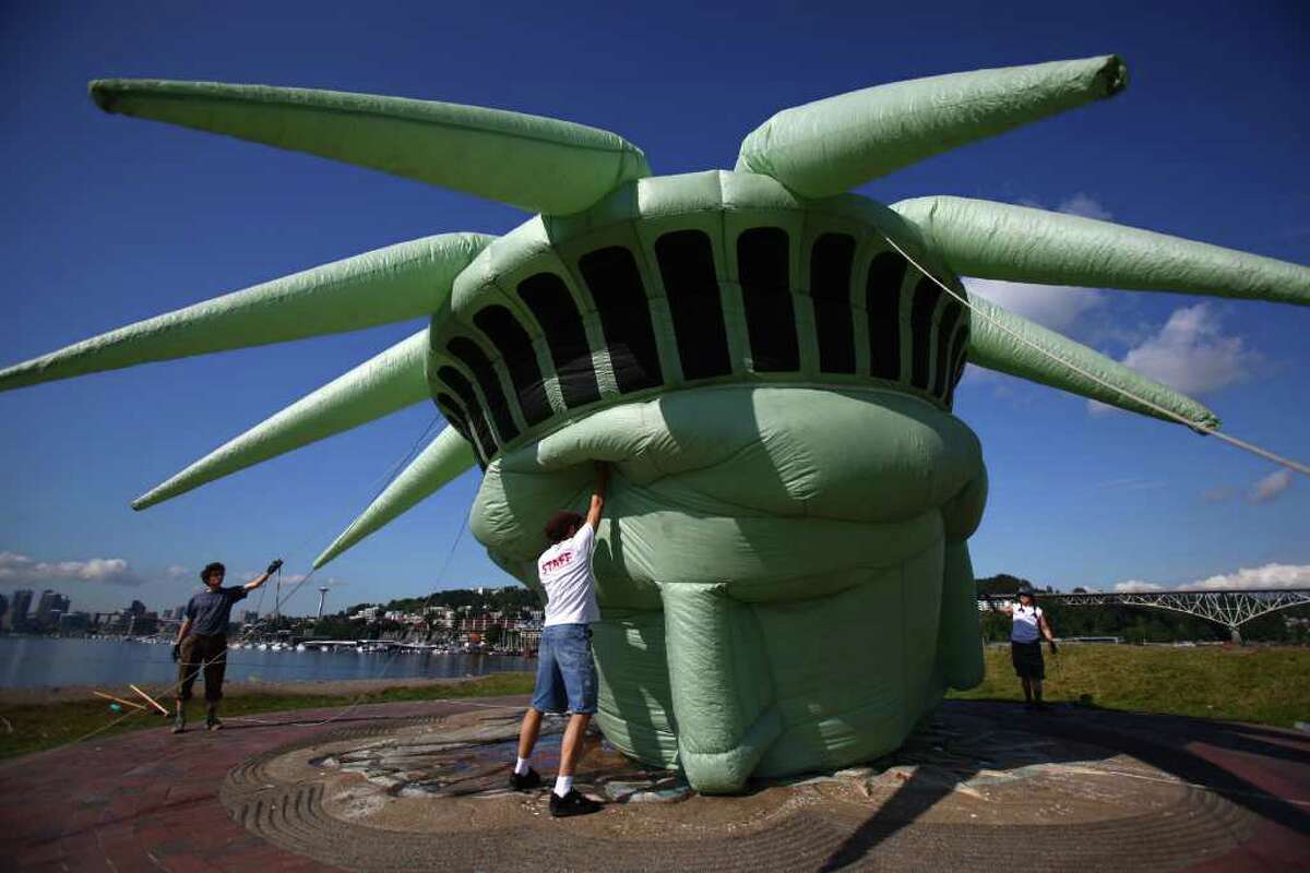 One Reel crew members work to inflate a life-size head of the Statue of Liberty on Friday.