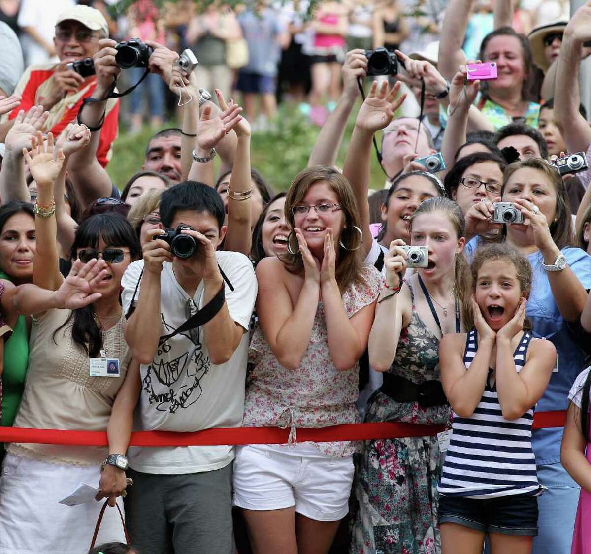 Royal fans try to catch a glimpse of Prince William, Duke of Cambridge and Catherine, Duchess of Cambridge as they visit Sainte-Justine University Hospital in Montreal on Saturday, July 2, 2011.  The newly married royal couple were on the third day of their first joint overseas tour. The 12-day visit to North America will take in some of the more remote areas of Canada, such as Prince Edward Island, Yellowknife and Calgary.