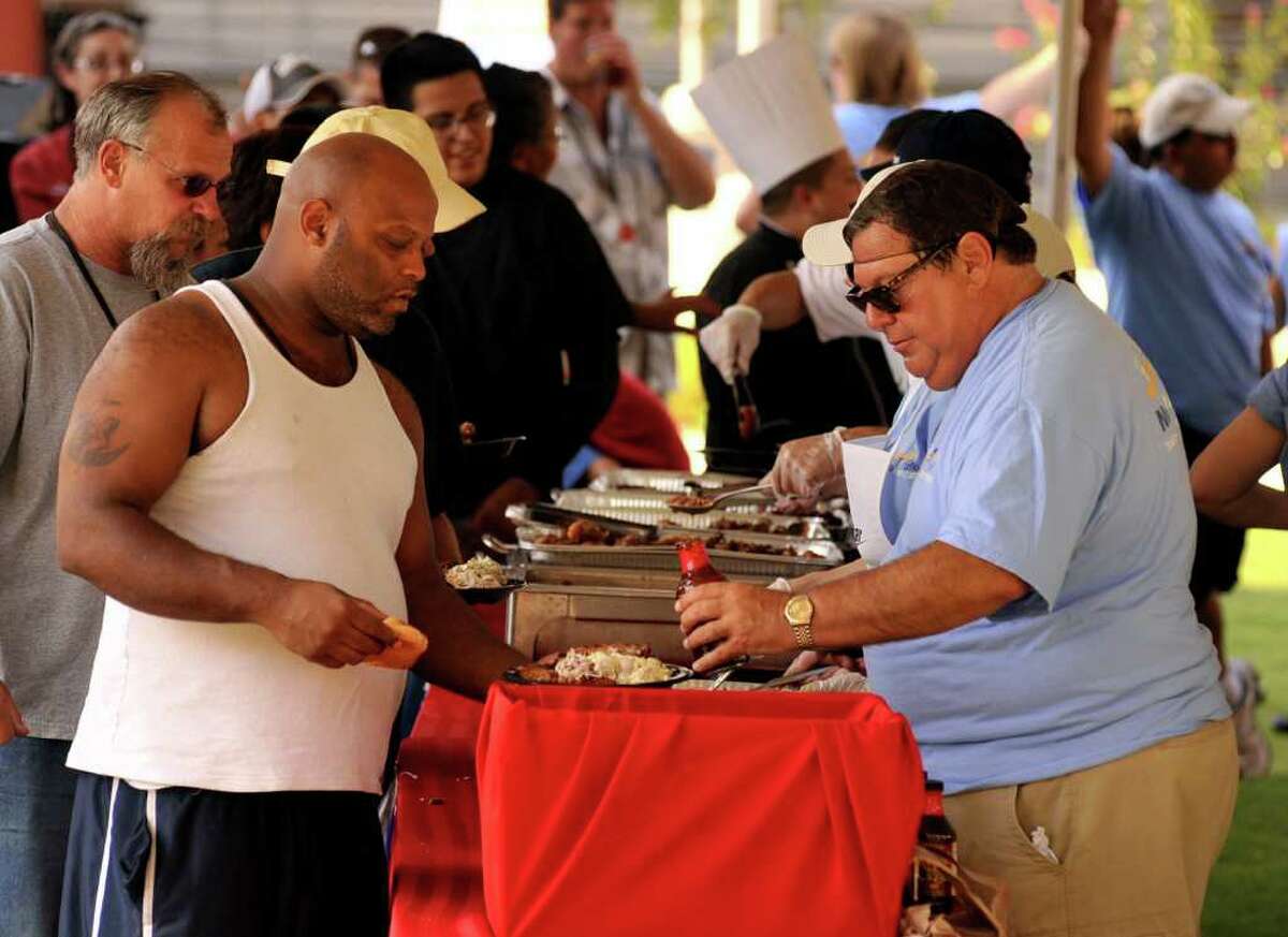 Greg Kaneb (right) serves barbecue to Sean Wharton during a one-year anniversary celebration for Haven for Hope on Wednesday, July 6, 2011, at the downtown campus for the homeless. NuStar Energy sponsored the barbecue.