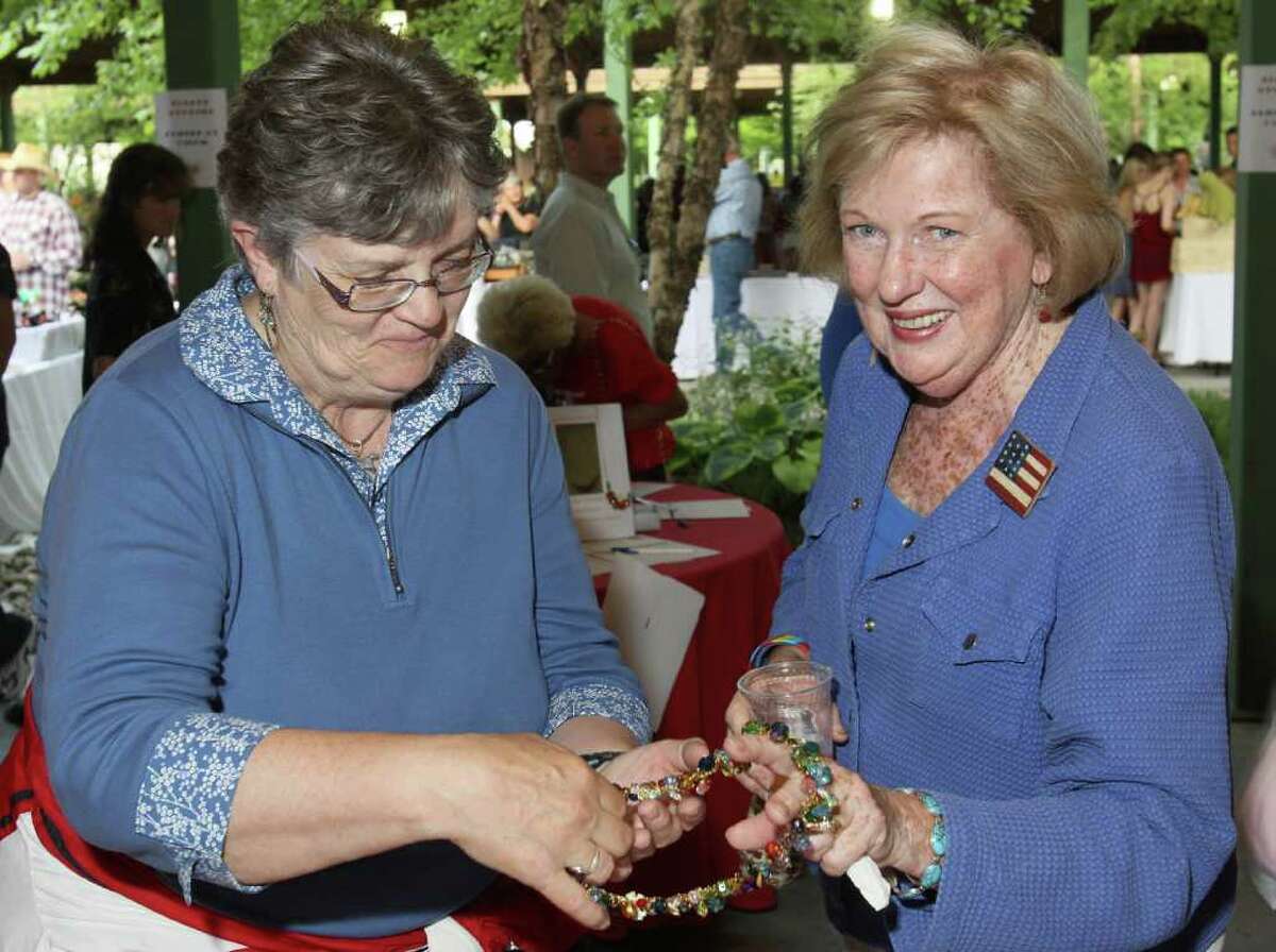 Lake George, NY - July 1, 2011 - (Photo by Joe Putrock/Special to the Times Union) - Event volunteer Sally Snowden(left) shows Judy Collins(right) a necklace from the silent auction table during the Double H Ranch 20th Anniversary Gala.