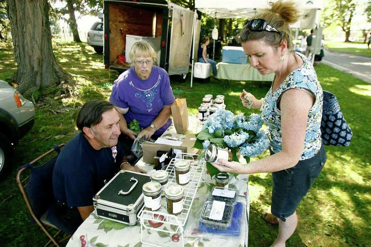 Jackie Barden, of Newtown, shops the Middlebrook Farm and Orchard stall with the help of owners John Mead and his wife, Marion Mead, at the Sandy Hook farmer's market at Fairfield Hills campus in Newtown on Tuesday, July 5, 2011. The Meads have been vendors with the Sandy Hook farmer's market for six years.