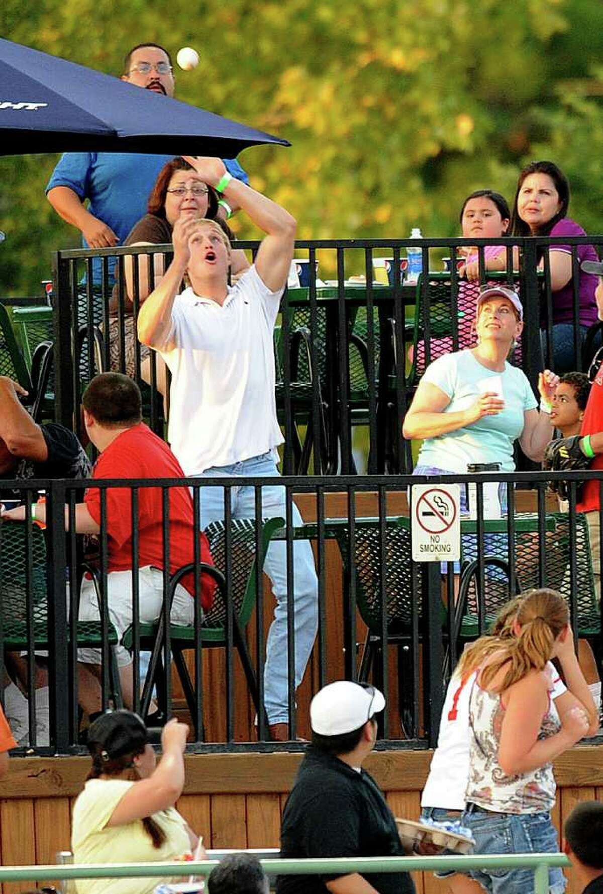 A fan reaches for a foul ball hit into the stands during Texas League action between the Northwest Arkansas Naturals and the San Antonio Missions at Wolff Stadium on Thursday, July 7, 2011. BILLY CALZADA / gcalzada@express-news.net