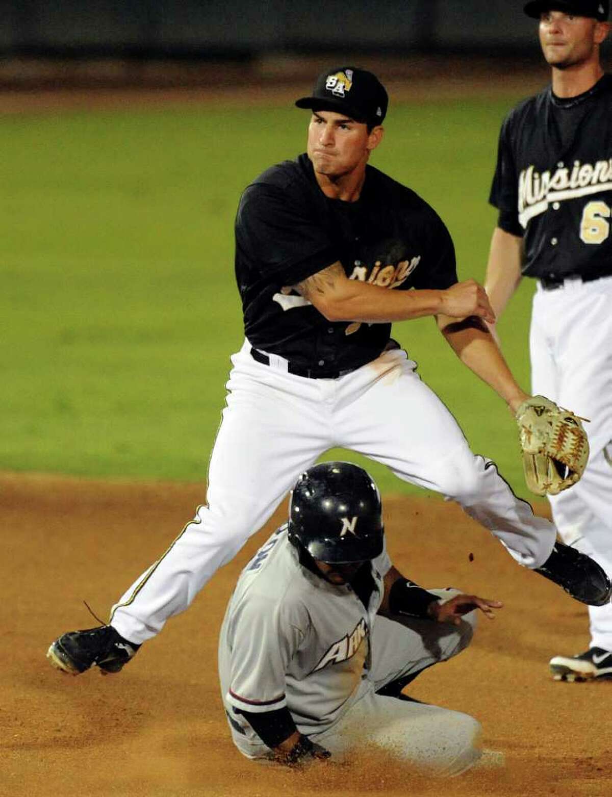 San Antonio Missions shortstop Dean Anna turns a double play as Christian Colon of the Northwest Arkansas Naturals slides in during Texas League action at Wolff Stadium on Thursday, July 7, 2011. BILLY CALZADA / gcalzada@express-news.net