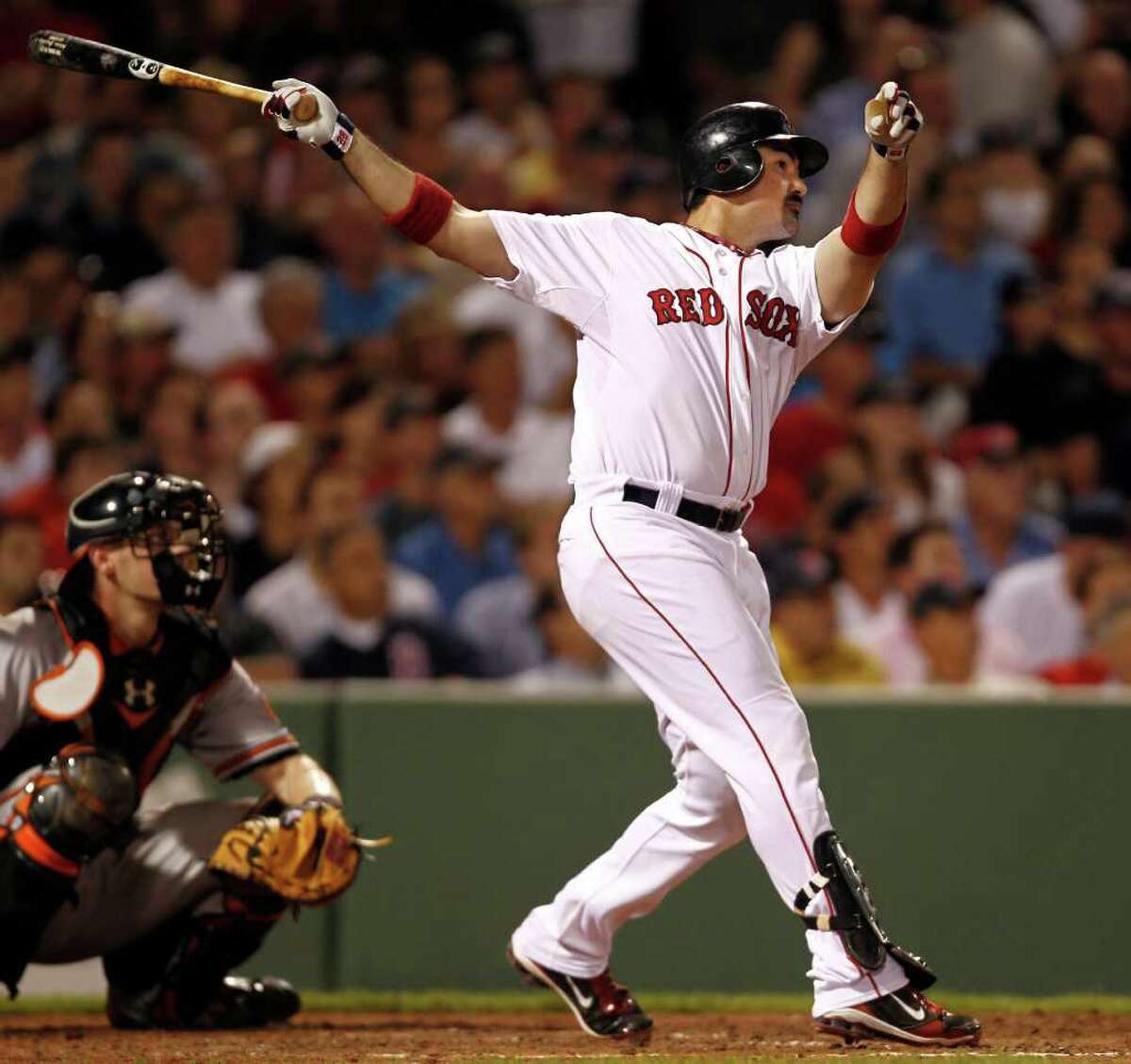 Boston Red Sox's Adrian Gonzalez watches his home run against the Baltimore Orioles during the fifth inning of a baseball game at Fenway Park in Boston on Thursday, July 7, 2011. Orioles catcher Matt Wieters is at left. (AP Photo/Winslow Townson)