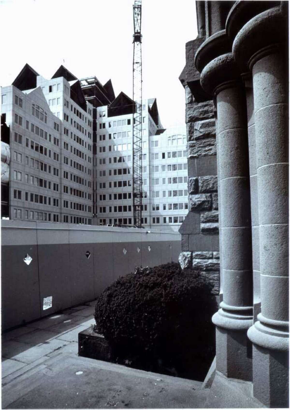 July 11, 1986: The new encirlces the old and both point to the sky outside St. John's Episcopal Church in Stamford. the church, with its columns visible on the right, faces Canterbury Green, an office, retail and residential complex under construction on Broad Street and Suburban Avenue.