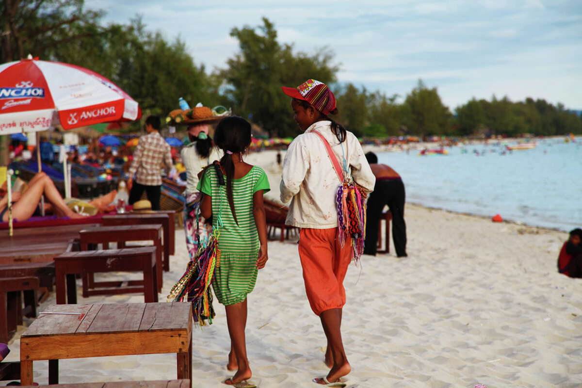 Young hawkers sell bracelets on the beach in Sihanoukville, Cambodia. Kevin Armstrong