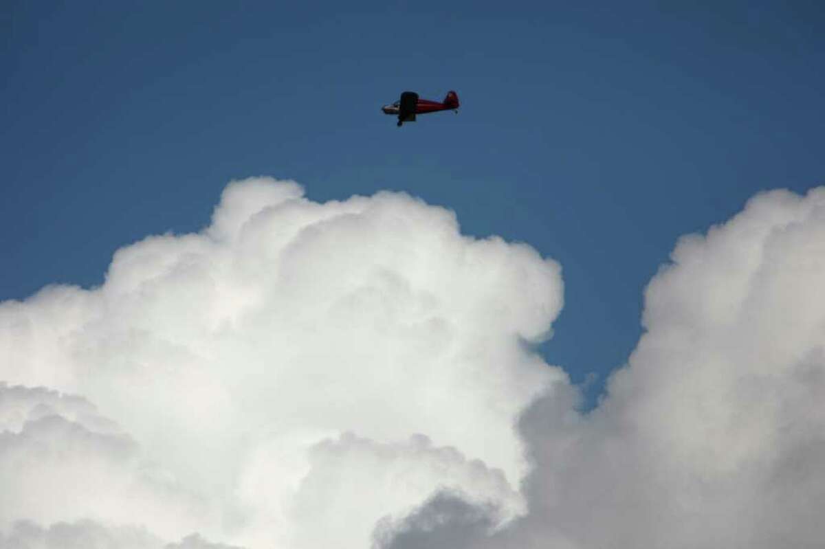 A plane flies over the airfield during the 2011Arlington Fly-In on Friday, July 8, 2011 at the Arlington Airport.