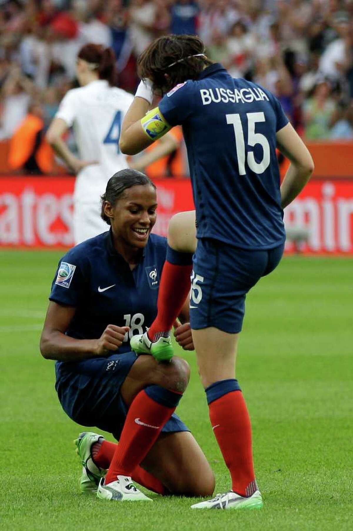 France's Marie-Laure Delie mockingly polishes Elise Bussaglia's shoe after she scored their side's first goal during the quarterfinal match between England and France at the Women?s Soccer World Cup in Leverkusen, Germany, Saturday, July 9, 2011. (AP Photo/Frank Augstein)