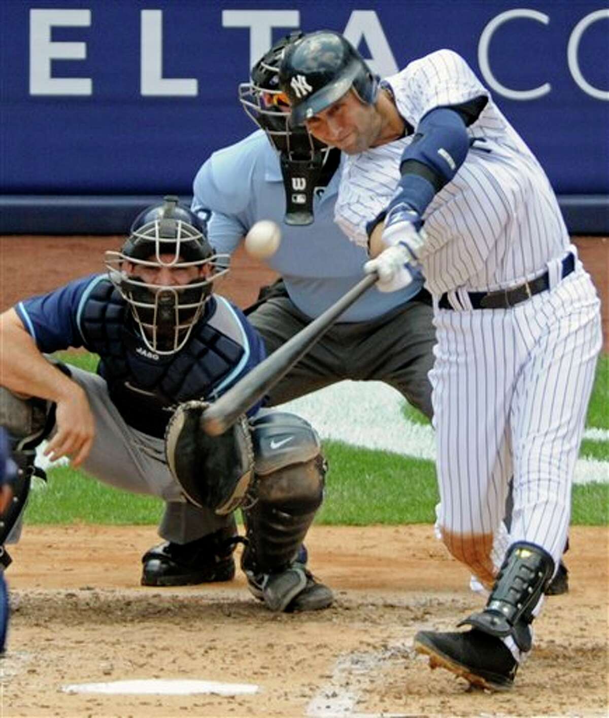 New York Yankees' Derek Jeter hits a home run for his 3,000th career hit during the third inning of a baseball game against the Tampa Bay Rays, Saturday, July 9, 2011, at Yankee Stadium in New York. Rays catcher John Jaso, pitcher David Price, left, and umpire Jim Wolf look on. Jeter became the 28th major leaguer to hit the milestone and also the first Yankees player. (AP Photo/Bill Kostroun)