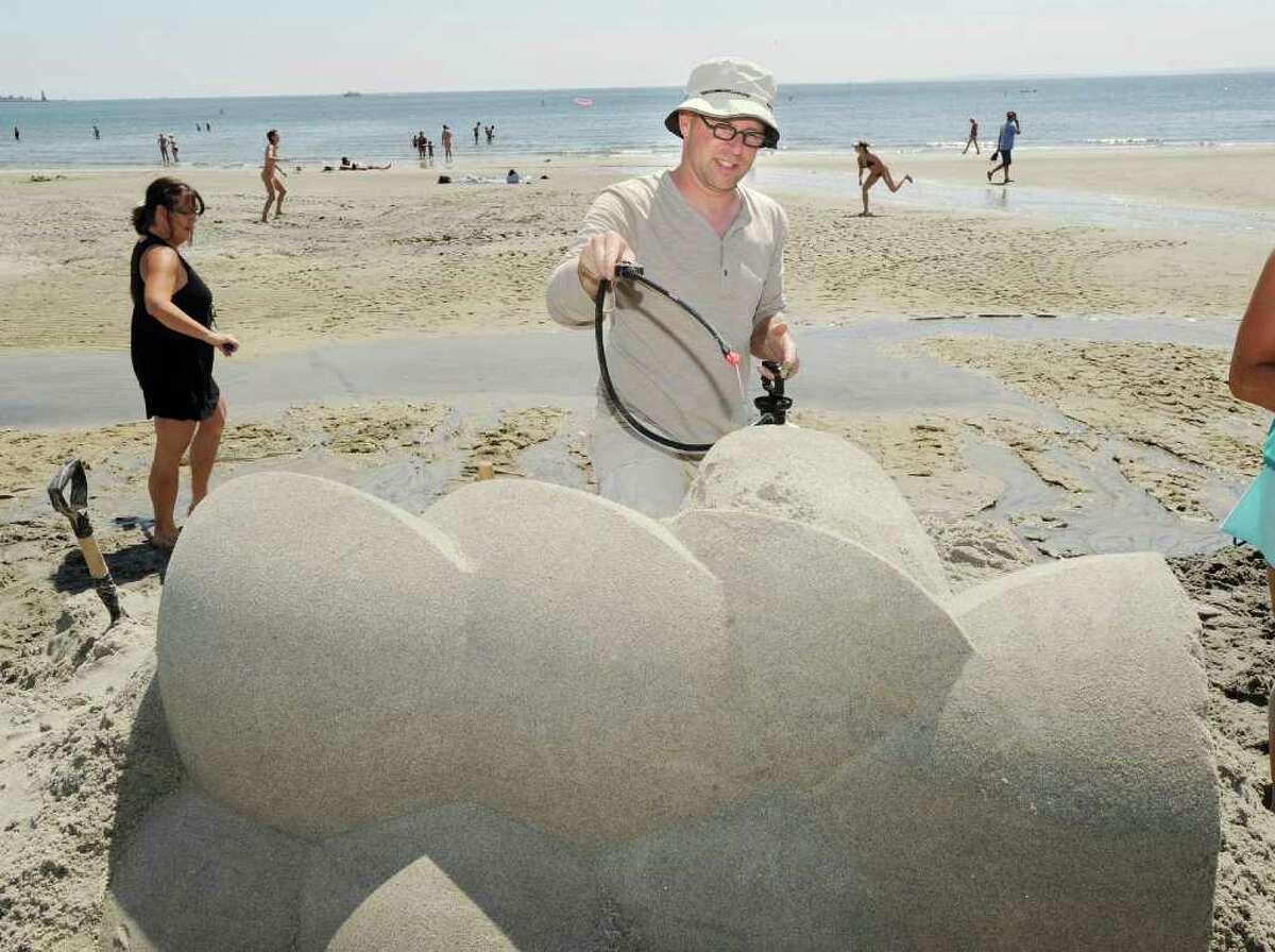 Wilfred Stijger of Katwijk, Holland, puts water onto his sand creation during the Greenwich Arts Council's Sand Blast!, sand sculpture festival, at Greenwich Point Saturday, July 9, 2011.
