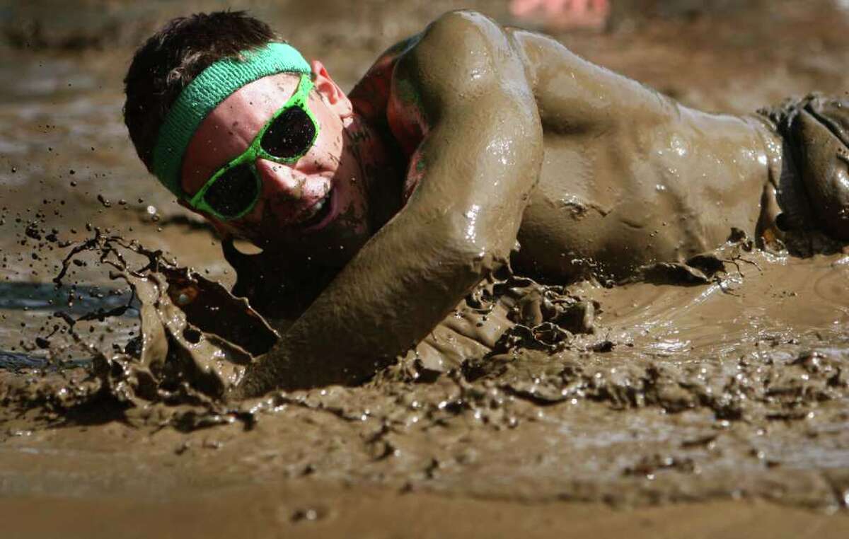 A participant slops through a mud pit during the Dirty Dash Seattle 10k mud run on Saturday, July 9, 2011 at PGP Motorsports Park in Kent.