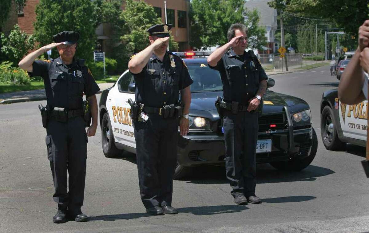 Bridgeport police officers, from left, Ken Ruge, Chuck Paris, and Paul Nikola, salute during the 18th annual Puerto Rican Day Parade in Bridgeport on Sunday, July 10, 2011.