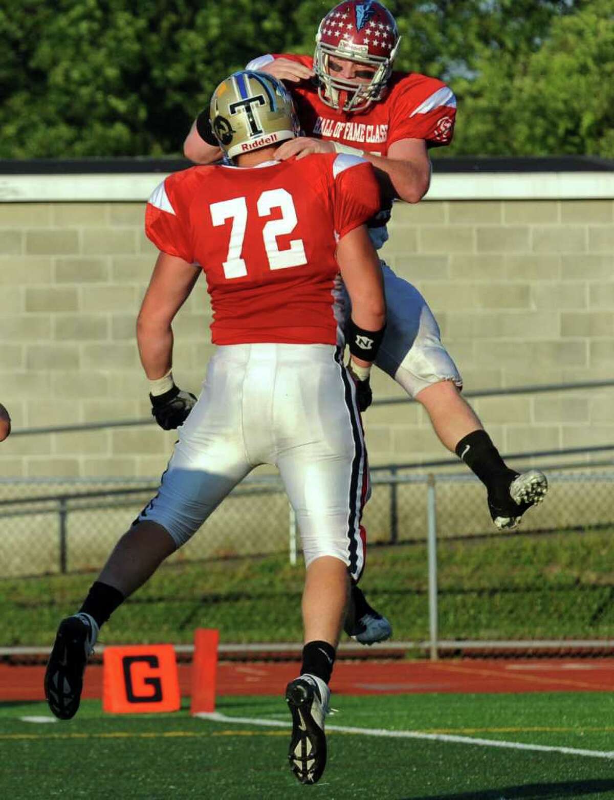 St. Joseph's #44 Tyler Matakevich, right, leaps in the air to celebrate his touchdown with teammate #72 Matt Datin, during Fairfield County vs. New Haven County All-star football action in West Haven, Conn. on Saturday July 9, 2011.
